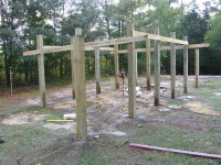 Viewed from the northeast.  The remaining posts for the center section have been set in concrete, leveled and secured to the temporary supports.  These are ten-foot-long six-by-six posts.