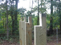 All posts for the outside walls of the side sections of the barn have been cut to exactly level height and have been mortised on the outside to accept the wall headers.