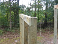 The twin-two-by-eight header is installed on the outside wall posts of the side sections of the barn.